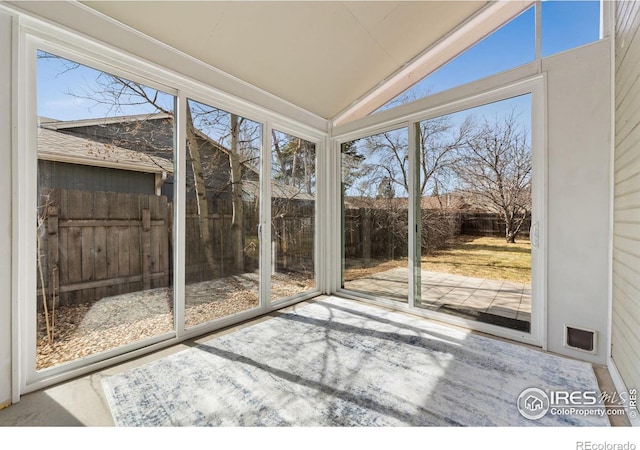 unfurnished sunroom featuring lofted ceiling and plenty of natural light