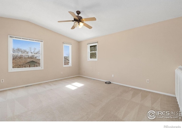 spare room featuring vaulted ceiling, a ceiling fan, baseboards, and carpet floors