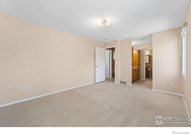 unfurnished bedroom featuring visible vents, carpet flooring, a textured ceiling, and baseboards