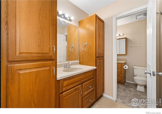 bathroom featuring vanity, toilet, and baseboards