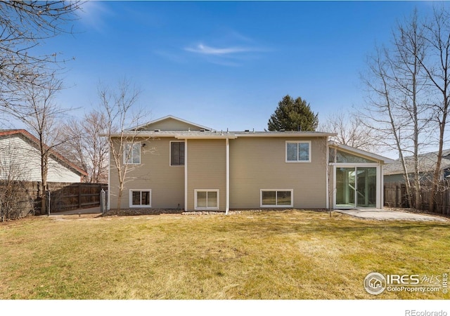 rear view of house featuring a yard, a patio, and a fenced backyard