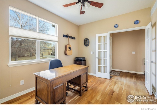 office space featuring french doors, baseboards, light wood-style floors, and a ceiling fan