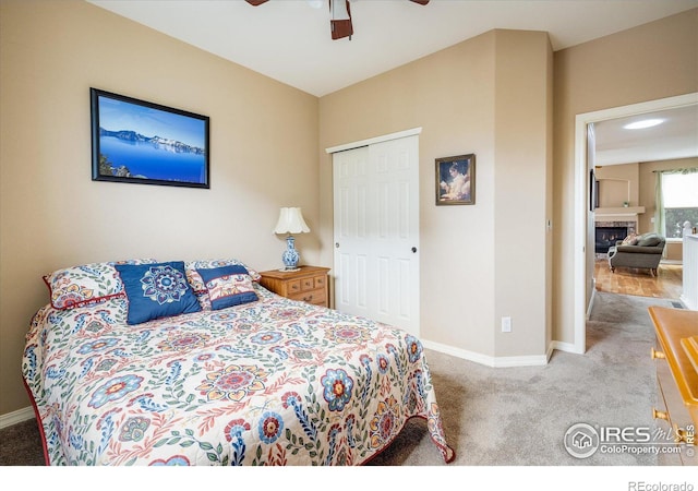 bedroom featuring baseboards, carpet floors, a closet, and a fireplace