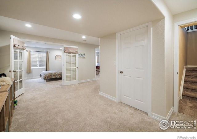 hallway with recessed lighting, french doors, baseboards, light colored carpet, and stairs