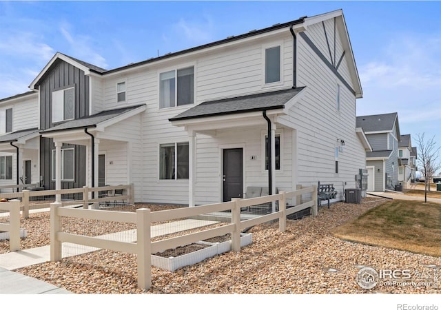 view of front of property featuring fence, board and batten siding, and central AC