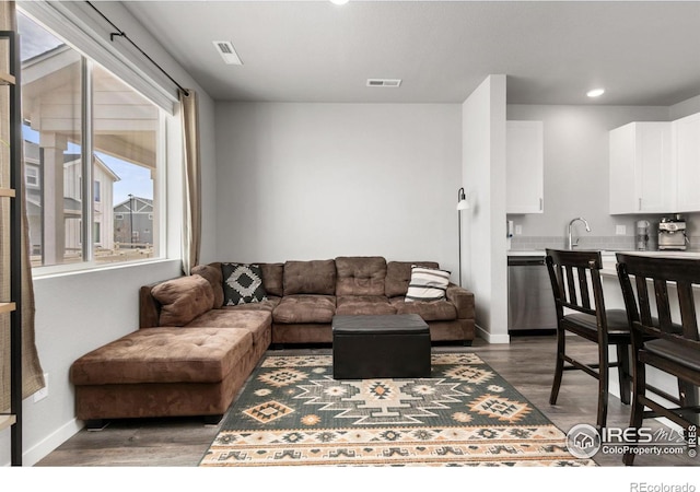 living room featuring recessed lighting, wood finished floors, visible vents, and baseboards