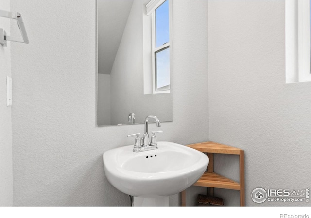 bathroom featuring a sink and a textured wall