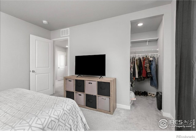 bedroom with baseboards, visible vents, carpet floors, a closet, and a walk in closet