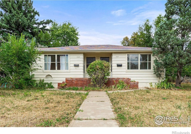 single story home featuring a front lawn