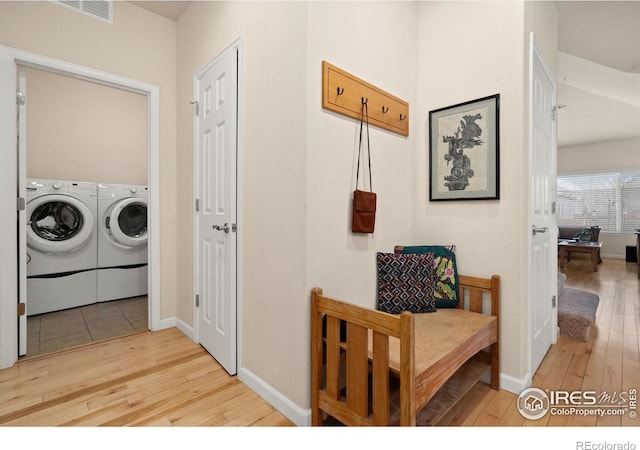 laundry room with visible vents, hardwood / wood-style flooring, laundry area, and washer and clothes dryer