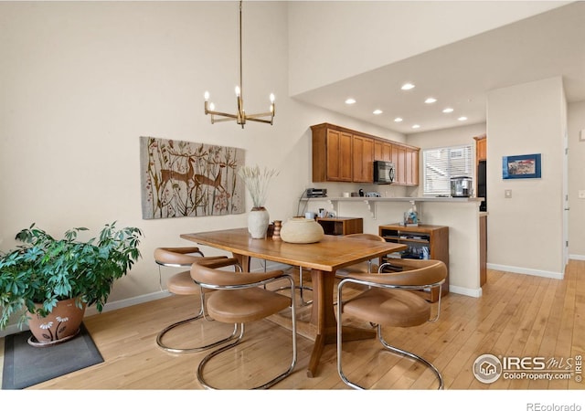 dining room with recessed lighting, baseboards, a notable chandelier, and light wood-style flooring