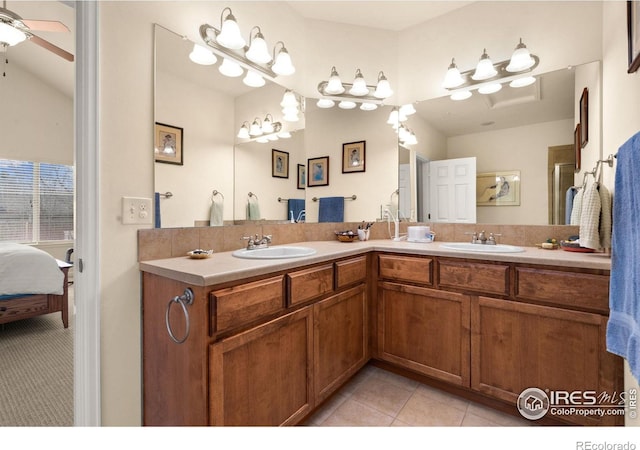 ensuite bathroom with tile patterned flooring, ensuite bath, a ceiling fan, and a sink