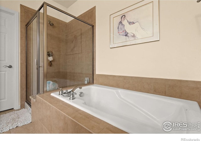 full bath featuring a shower stall and a garden tub