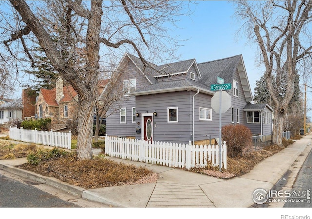 view of front of property featuring a fenced front yard and roof with shingles