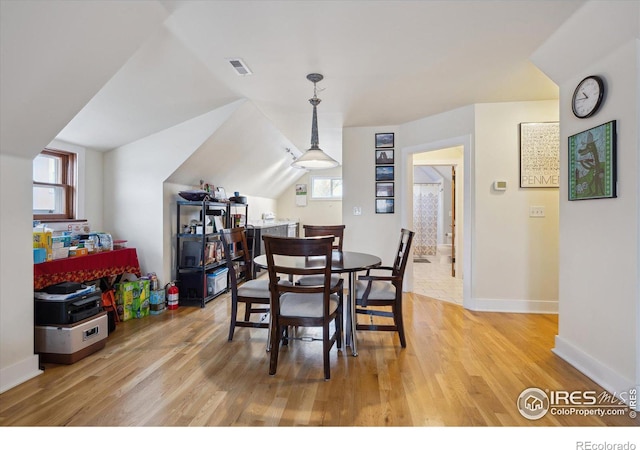 dining room with light wood-type flooring, visible vents, baseboards, and a wealth of natural light