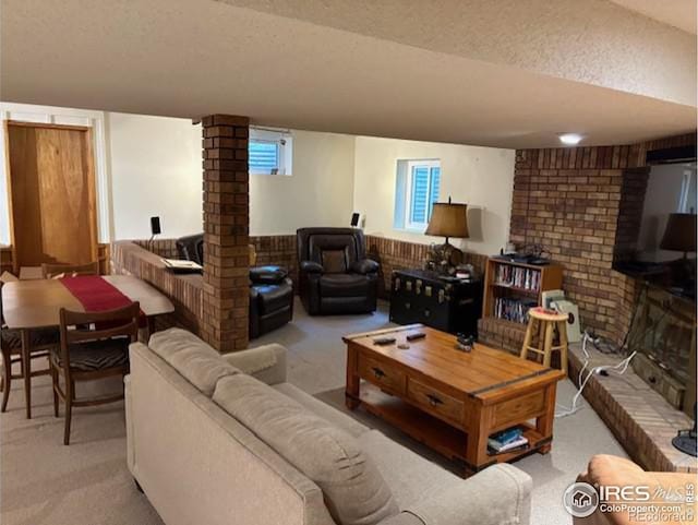 living room with a brick fireplace, carpet floors, and a textured ceiling