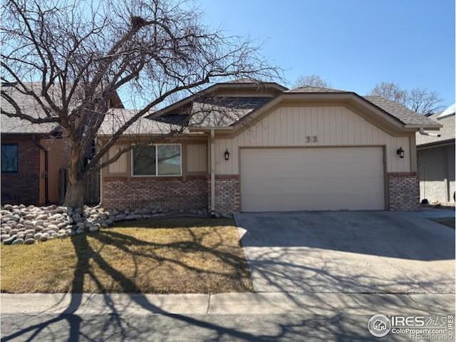 ranch-style house featuring a front lawn, an attached garage, brick siding, and driveway