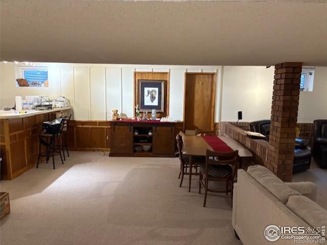 dining area featuring decorative columns and light carpet