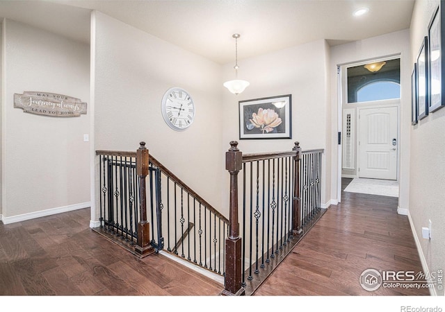 hall featuring wood finished floors, recessed lighting, an upstairs landing, and baseboards