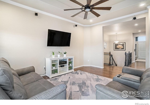 living room featuring crown molding, ceiling fan, baseboards, recessed lighting, and wood finished floors