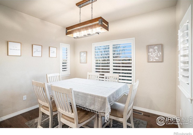 dining area with baseboards and dark wood-style flooring