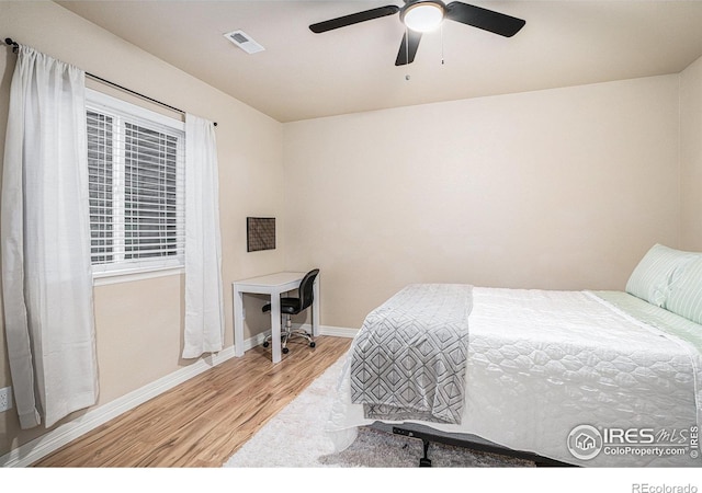 bedroom featuring visible vents, light wood-style flooring, baseboards, and ceiling fan