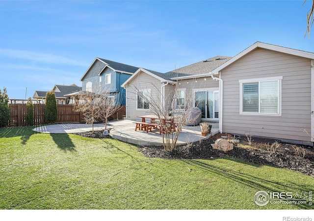 rear view of house featuring a patio, a lawn, and fence