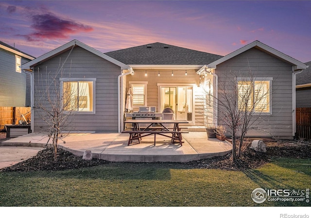 rear view of property with a yard, a patio, and fence