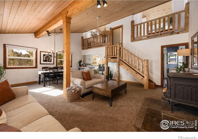 carpeted living room featuring beamed ceiling, a healthy amount of sunlight, wooden ceiling, and stairs