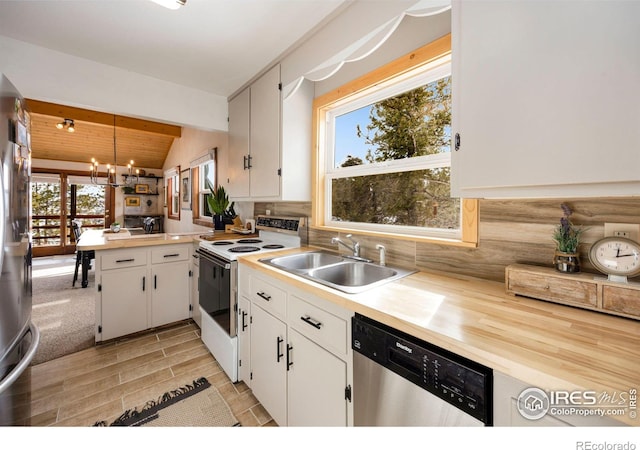 kitchen featuring a sink, stainless steel appliances, a peninsula, light countertops, and decorative backsplash