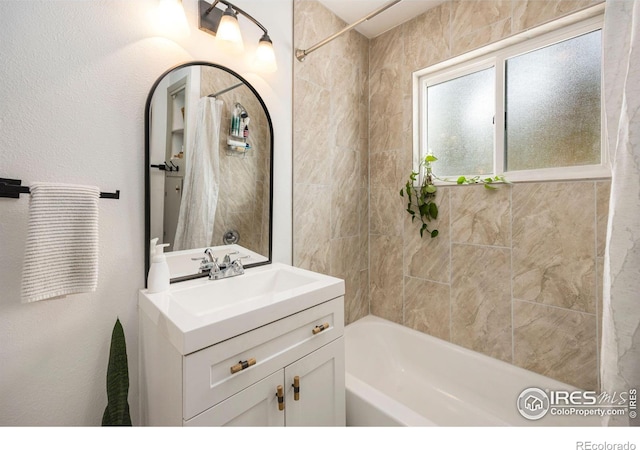 bathroom with vanity,  shower combination, and a textured wall