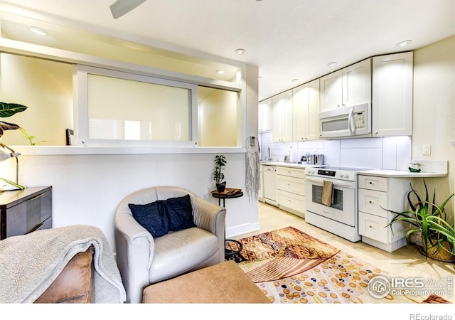 kitchen featuring white appliances, recessed lighting, light countertops, white cabinetry, and tasteful backsplash