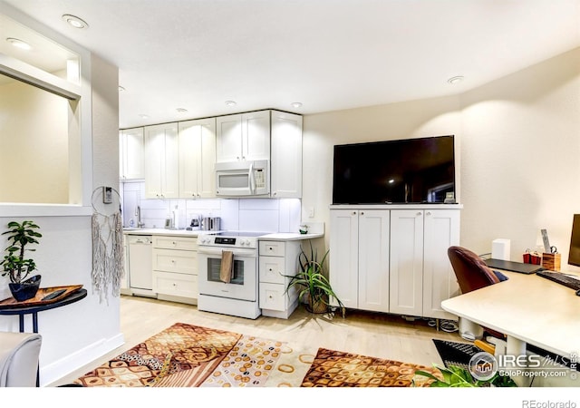 kitchen with white appliances, recessed lighting, light countertops, white cabinetry, and light wood-type flooring