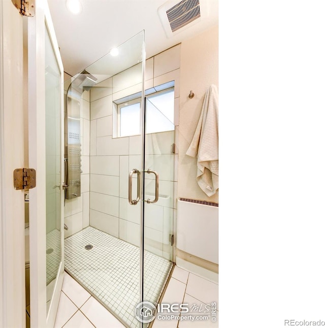 bathroom featuring tile patterned flooring, visible vents, and a stall shower