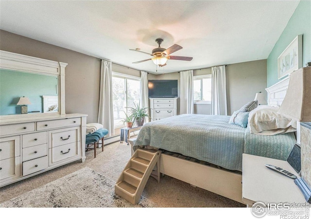 bedroom with light colored carpet, a textured ceiling, and a ceiling fan