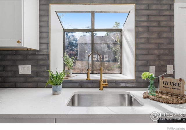 interior details featuring a sink and white cabinetry