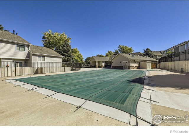 pool featuring a residential view, a patio, and fence