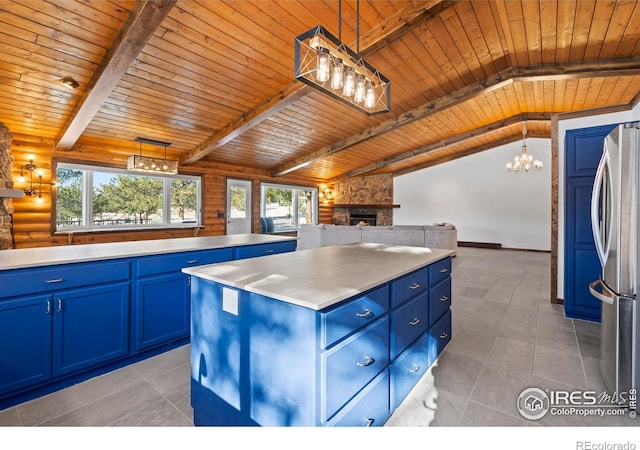 871 E Ln, Estes Park, CO 80517 - kitchen with blue cabinetry, open floor plan, freestanding refrigerator, a stone fireplace, and wooden ceiling