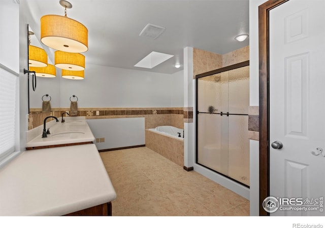 871 E Ln, Estes Park, CO 80517 - full bathroom featuring a bath, a stall shower, a skylight, and double vanity