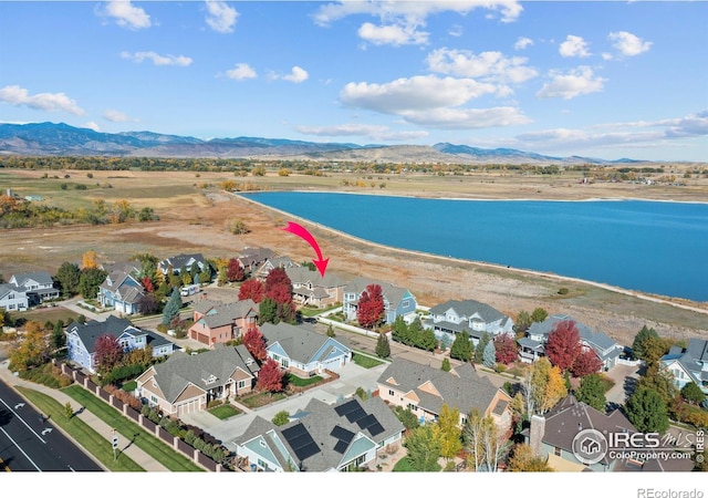 drone / aerial view with a residential view and a water and mountain view