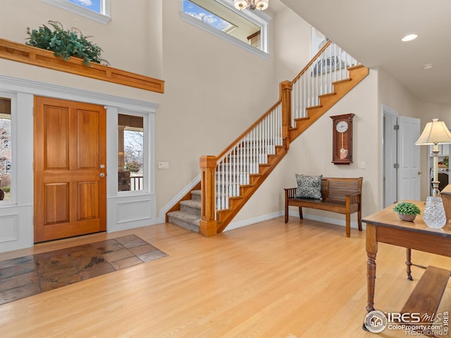 foyer entrance featuring stairs, plenty of natural light, and wood finished floors