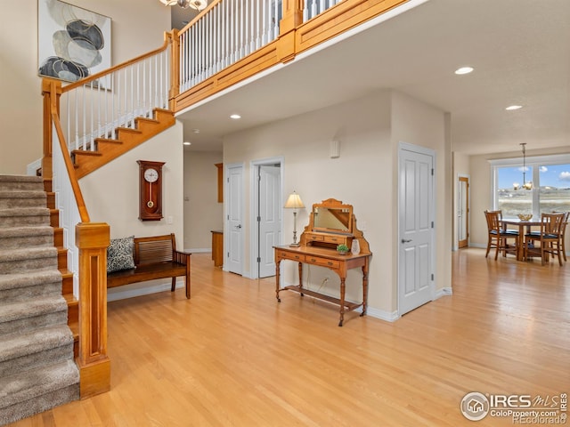 interior space with a towering ceiling, recessed lighting, baseboards, and wood finished floors