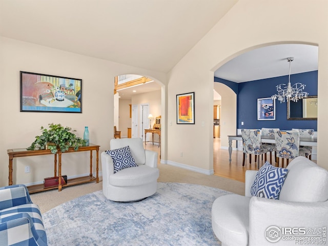 living area featuring baseboards, carpet floors, vaulted ceiling, arched walkways, and a notable chandelier