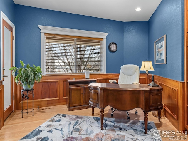 home office with recessed lighting, a wainscoted wall, and light wood-style flooring