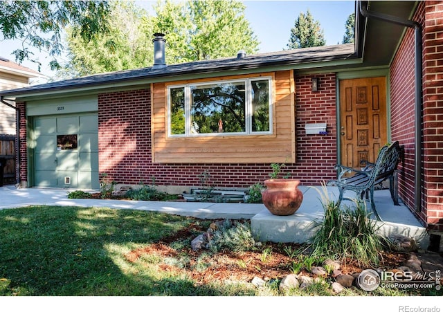 exterior space featuring brick siding, a front lawn, and a garage