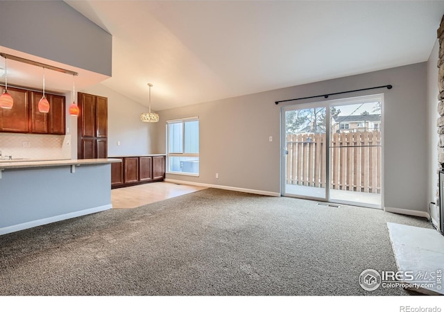 unfurnished living room featuring baseboards, light carpet, and vaulted ceiling