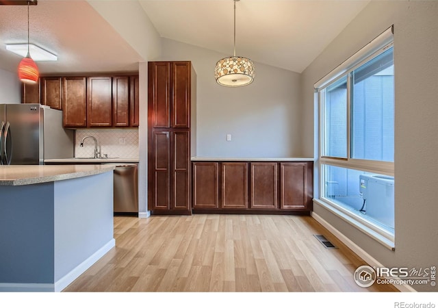 kitchen with stainless steel appliances, lofted ceiling, visible vents, and hanging light fixtures