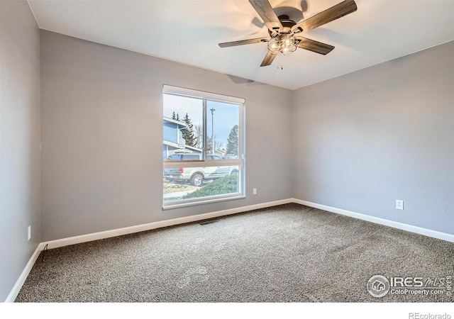 unfurnished room with a ceiling fan, carpet, visible vents, and baseboards