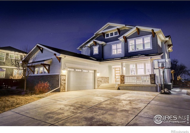 craftsman house with stone siding, central AC unit, covered porch, and concrete driveway