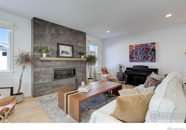 living area featuring recessed lighting, wood finished floors, and a tiled fireplace